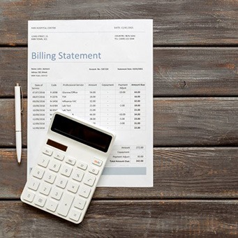 Billing statement and calculator on top of wooden table