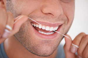 Close-up of man flossing his teeth